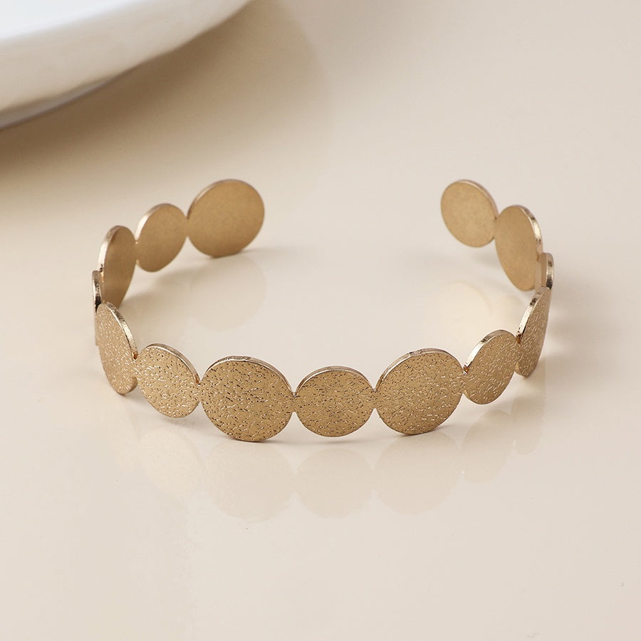 Brushed textured faux gold plated discs open back bangle