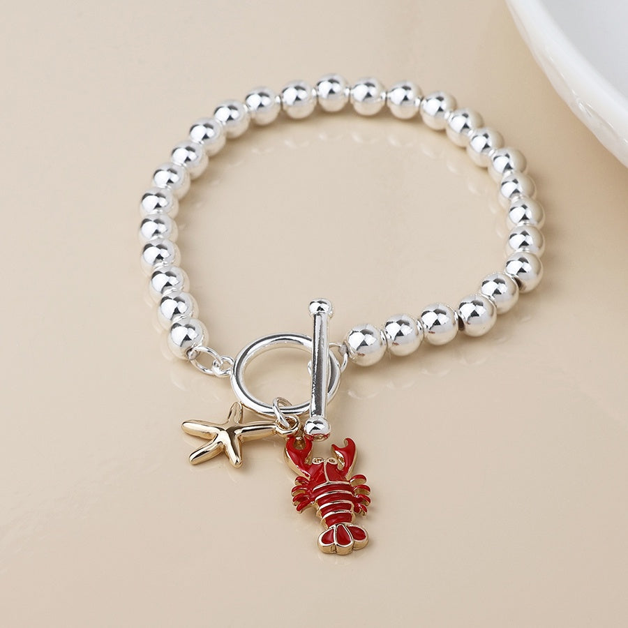 Silver plated t bar bracelet with lobster and gold starfish charms